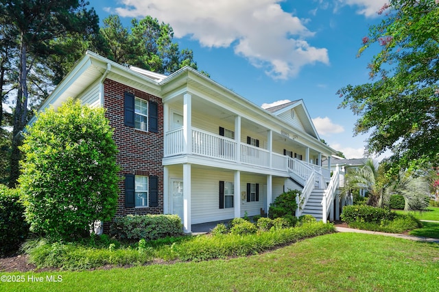 view of front of property featuring a front lawn, a balcony, and a porch