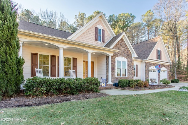 view of front of home with a garage, covered porch, and a front lawn