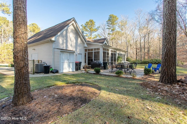 view of home's exterior with a yard, central AC unit, a patio area, and a sunroom