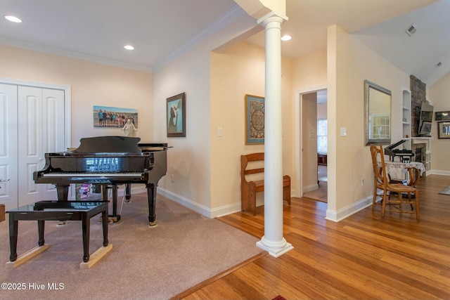 misc room featuring ornamental molding, light hardwood / wood-style floors, and ornate columns