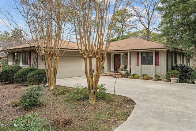 ranch-style house featuring roof with shingles, driveway, and an attached garage