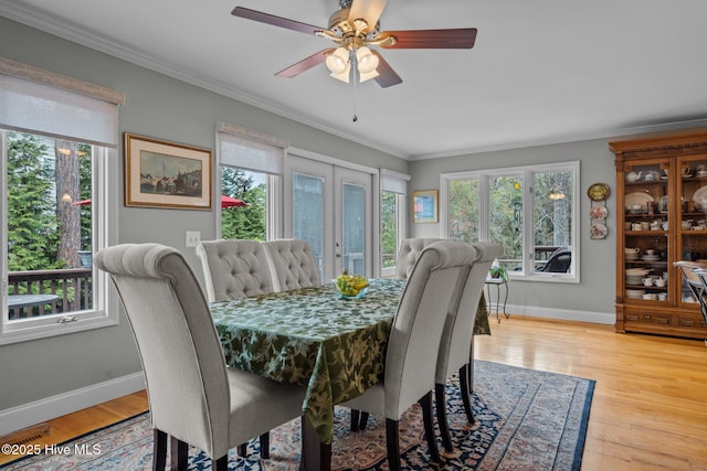 dining room featuring ornamental molding, plenty of natural light, and wood finished floors