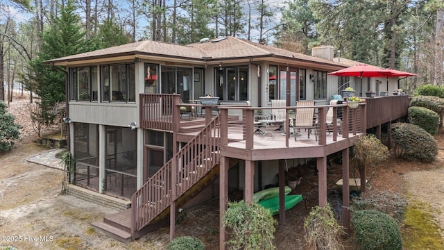 rear view of house with a sunroom, stairs, a chimney, and a wooden deck