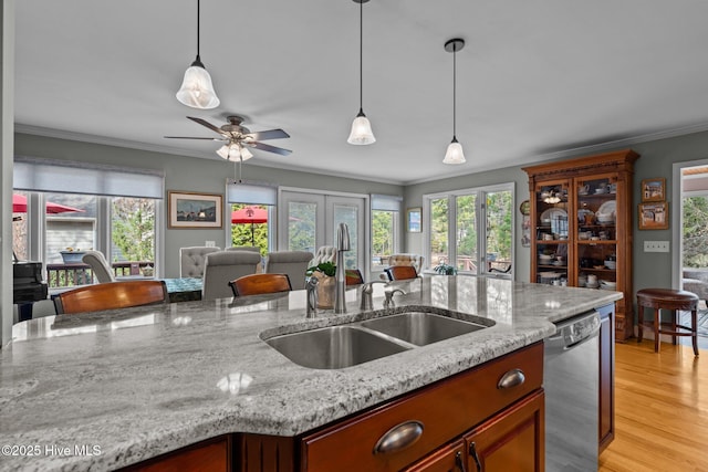 kitchen featuring open floor plan, stainless steel dishwasher, and crown molding