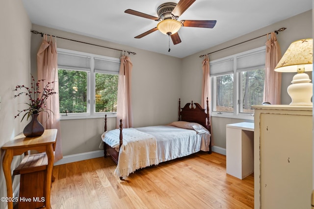 bedroom featuring light wood-style flooring, multiple windows, and baseboards