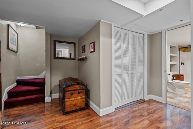 corridor with baseboards, stairway, and wood finished floors