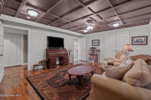 living area featuring ceiling fan, wood-type flooring, coffered ceiling, and baseboards