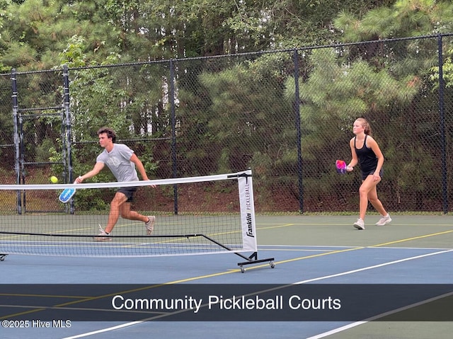 view of tennis court featuring fence