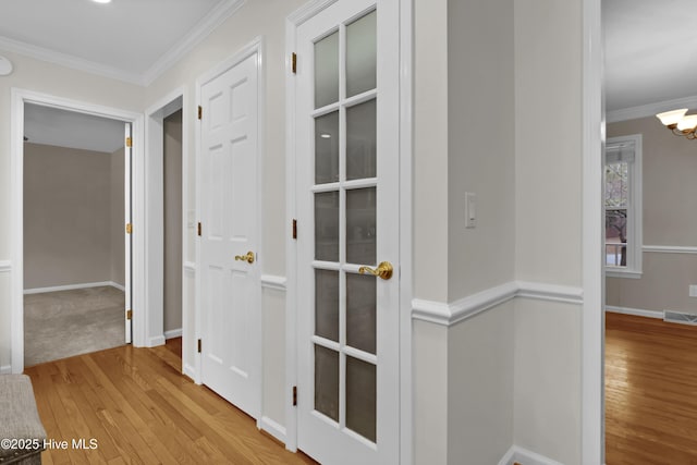 hall with crown molding and light hardwood / wood-style flooring