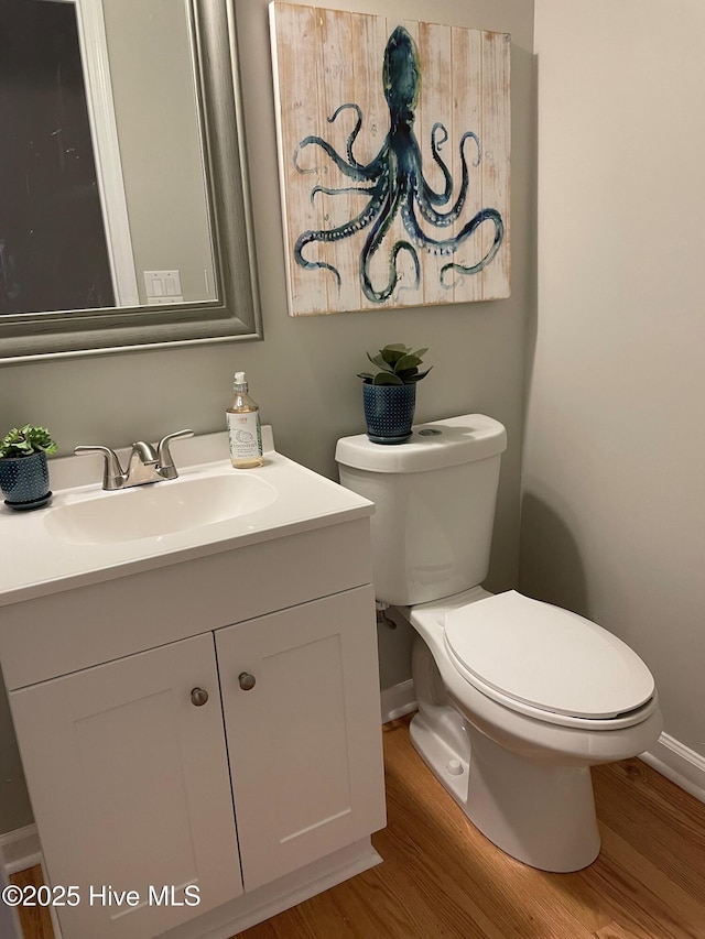 bathroom featuring wood-type flooring, vanity, and toilet