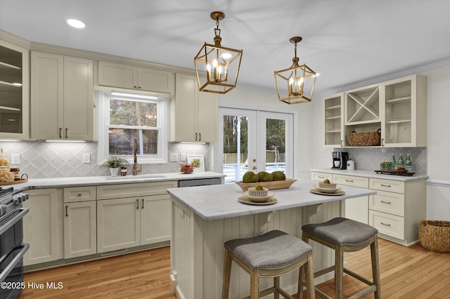 kitchen featuring a breakfast bar, sink, decorative light fixtures, a center island, and stainless steel range