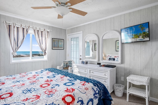 carpeted bedroom with crown molding, a textured ceiling, ceiling fan, and a water view