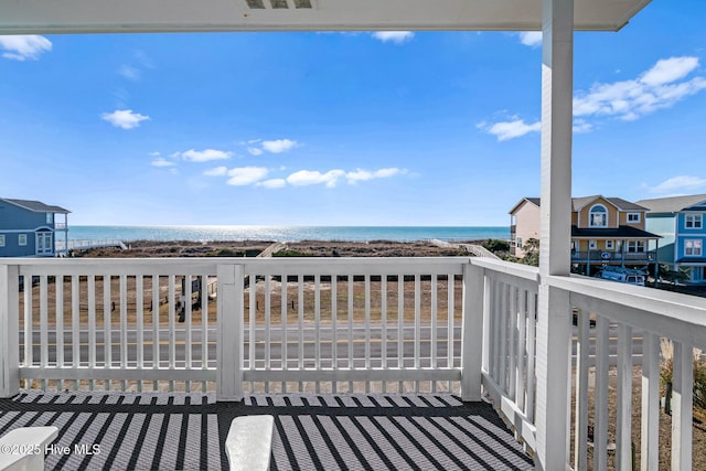 wooden terrace with a water view and a view of the beach