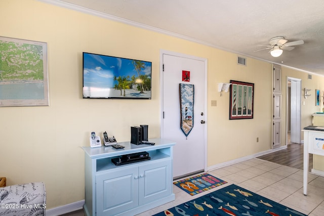 interior space featuring crown molding, light tile patterned floors, ceiling fan, and a textured ceiling