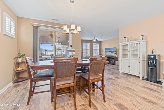 dining area featuring ceiling fan with notable chandelier and light hardwood / wood-style floors