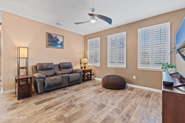 living room featuring light hardwood / wood-style floors and ceiling fan