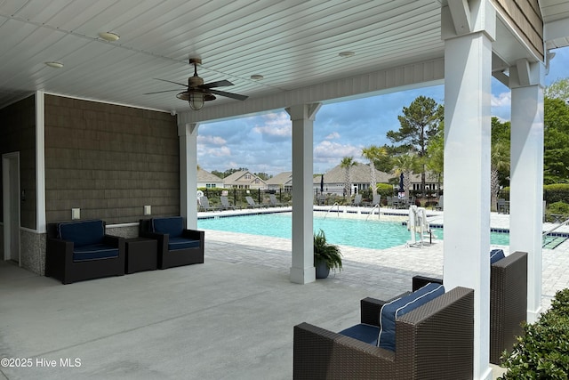 view of swimming pool with ceiling fan and a patio area