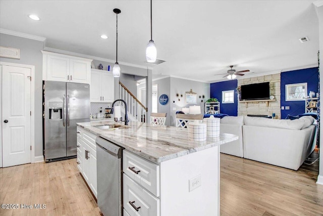 kitchen featuring ceiling fan, appliances with stainless steel finishes, sink, and a kitchen island with sink