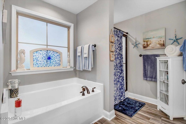 bathroom featuring a healthy amount of sunlight, independent shower and bath, and hardwood / wood-style flooring