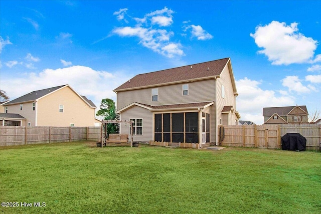 rear view of house with a yard and a sunroom