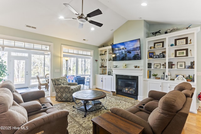 living room featuring ceiling fan, vaulted ceiling, and light hardwood / wood-style flooring