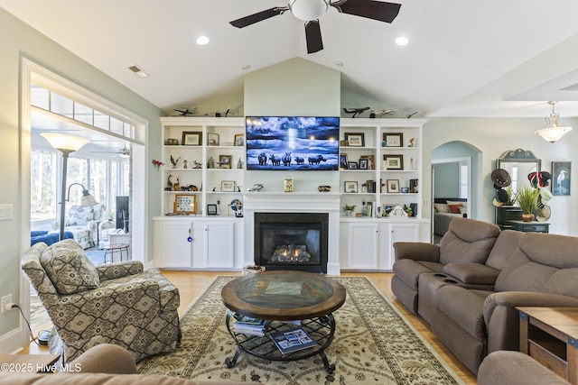 living room with ceiling fan, vaulted ceiling, and light hardwood / wood-style floors