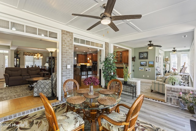 dining area featuring ceiling fan with notable chandelier and light wood-type flooring