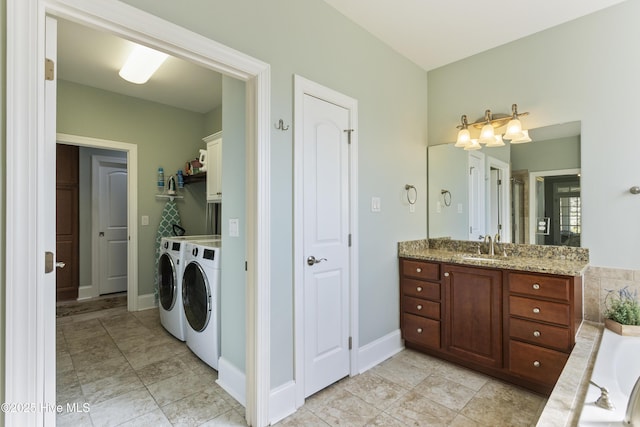 bathroom with vanity, a bath, and washing machine and clothes dryer