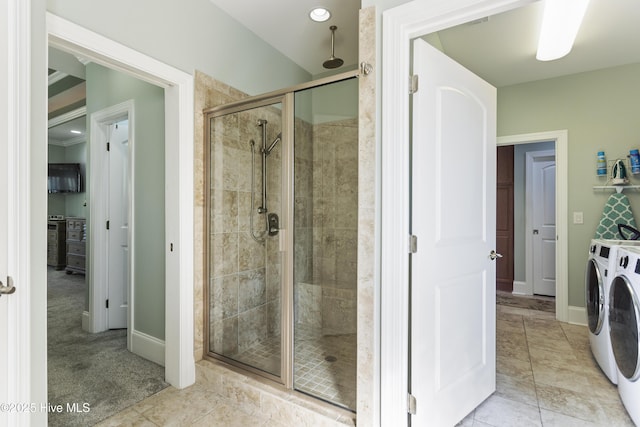 bathroom with washer and clothes dryer and a shower with door