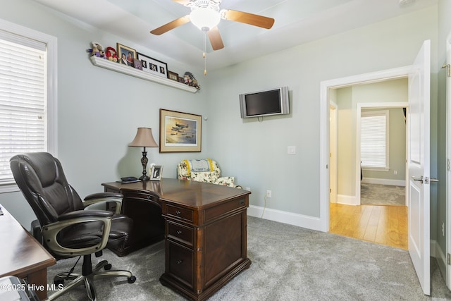 office space featuring ceiling fan and light carpet