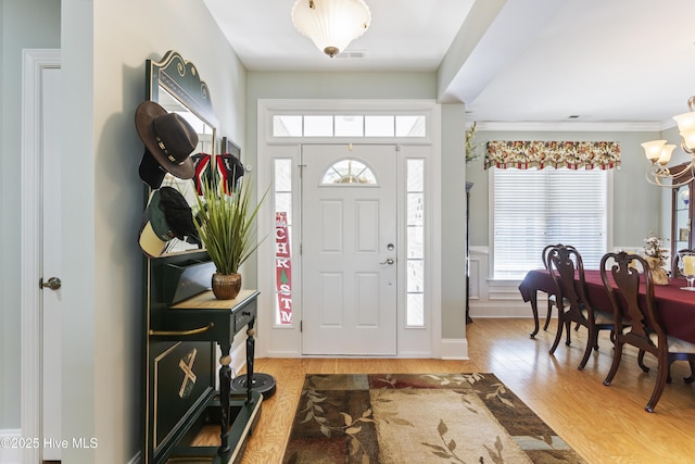 entryway with light wood-type flooring and an inviting chandelier