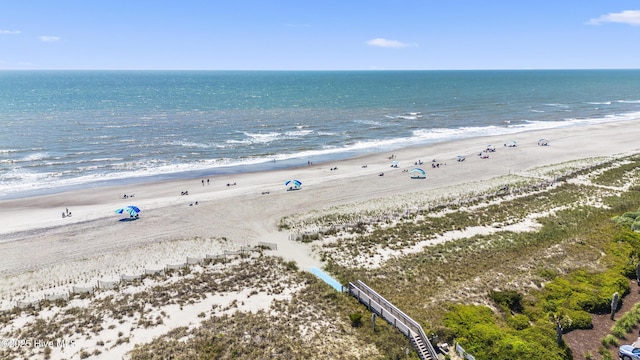 birds eye view of property with a water view and a beach view