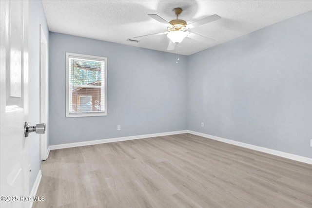 empty room with ceiling fan, a textured ceiling, and light wood-type flooring