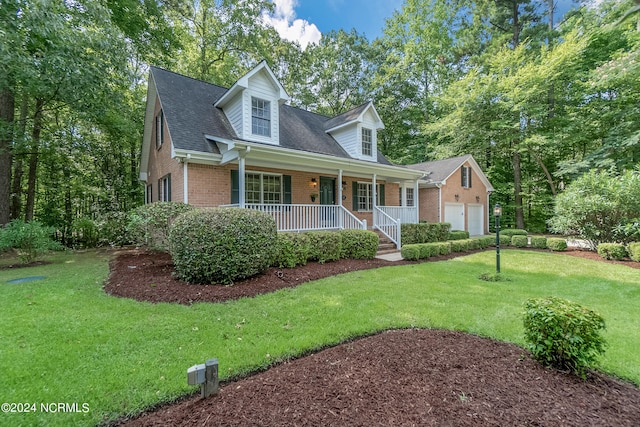 new england style home with a front yard, a porch, and a garage