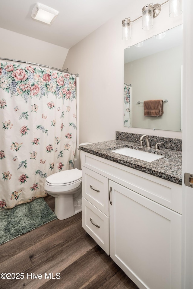 bathroom with vanity, hardwood / wood-style floors, walk in shower, and toilet