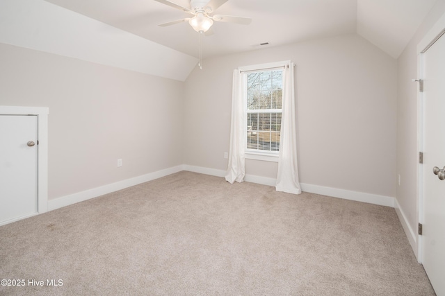 additional living space with vaulted ceiling, light colored carpet, and ceiling fan