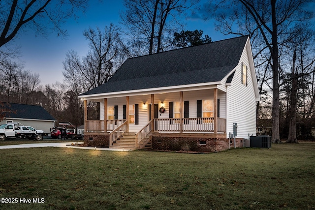 view of front of property featuring a yard, covered porch, and central air condition unit