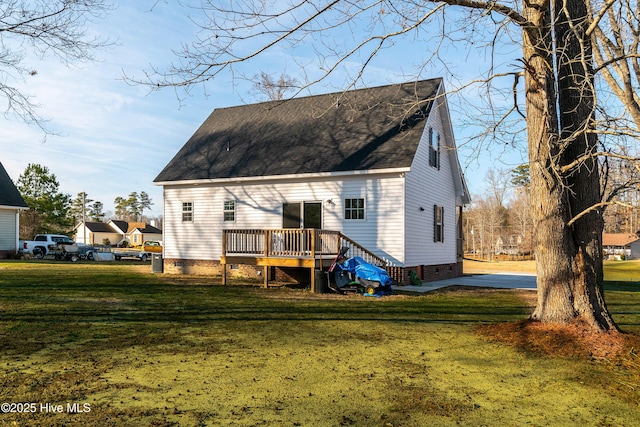 rear view of property with a wooden deck and a lawn