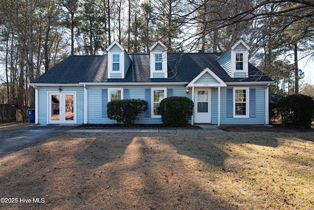 cape cod home with a front lawn and french doors