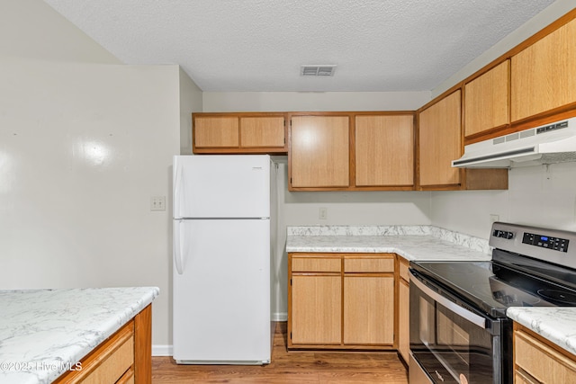 kitchen featuring electric range, white refrigerator, a textured ceiling, and light hardwood / wood-style flooring