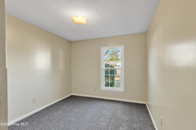 carpeted spare room with a textured ceiling