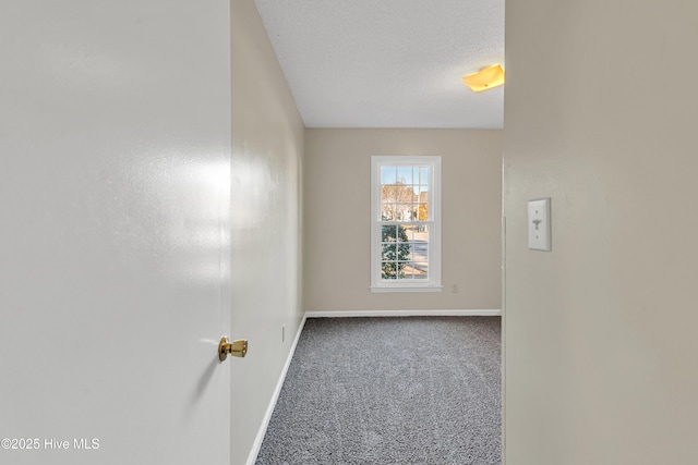 carpeted empty room with a textured ceiling