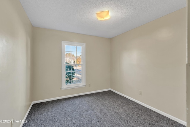 empty room with carpet and a textured ceiling