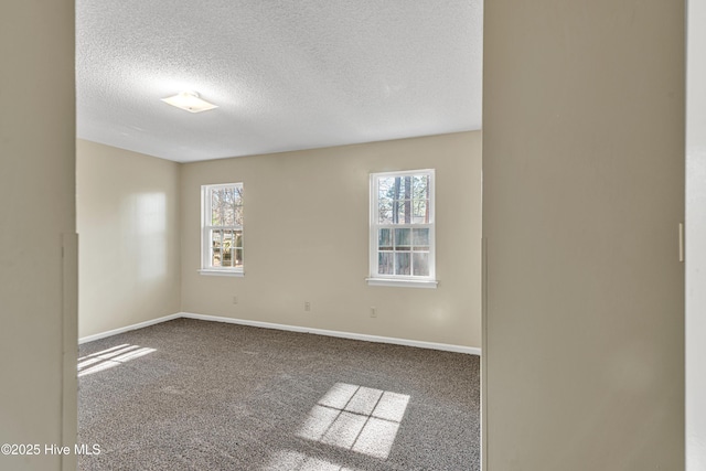 carpeted spare room with a textured ceiling