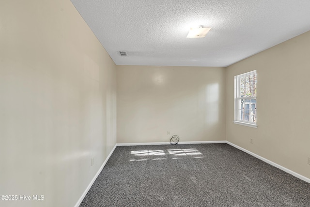 unfurnished room featuring a textured ceiling and carpet