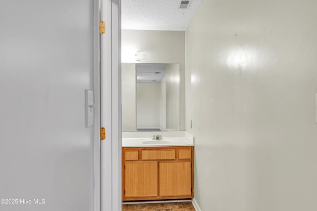 bathroom featuring a textured ceiling and vanity