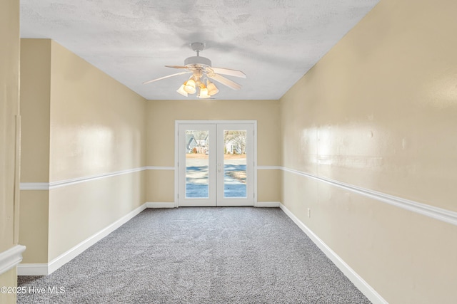 carpeted empty room featuring a textured ceiling, ceiling fan, and french doors