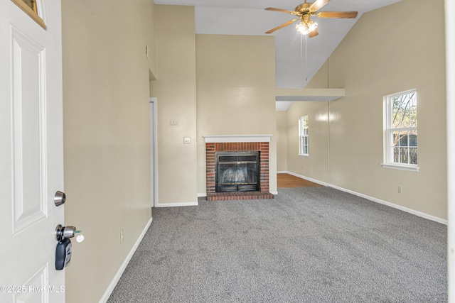 unfurnished living room featuring a brick fireplace, high vaulted ceiling, carpet floors, and ceiling fan