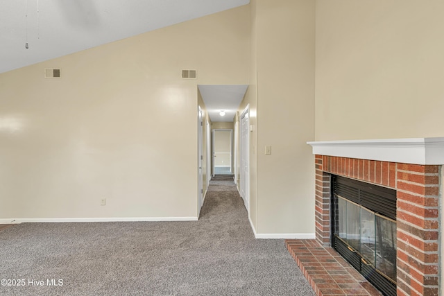 unfurnished living room with a brick fireplace, carpet, and lofted ceiling