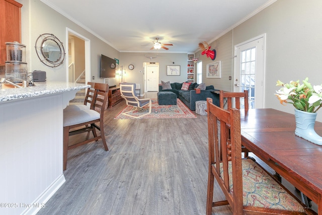 dining room with ceiling fan, crown molding, and dark hardwood / wood-style flooring